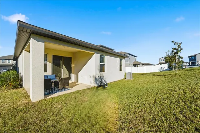 a backyard of a house with table and chairs