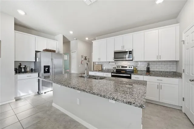 a kitchen with granite countertop a stove sink and cabinets
