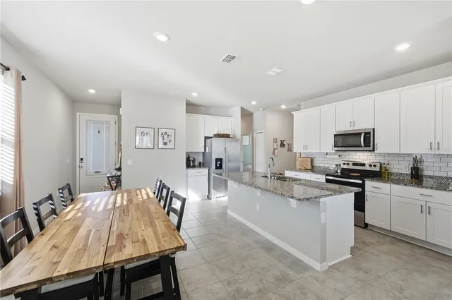 a kitchen with stainless steel appliances kitchen island granite countertop a sink and cabinets