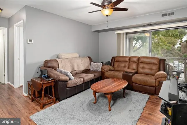 a living room with furniture a ceiling fan and a window