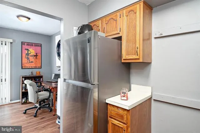 a area with stainless steel appliances granite countertop a refrigerator and a stove top oven