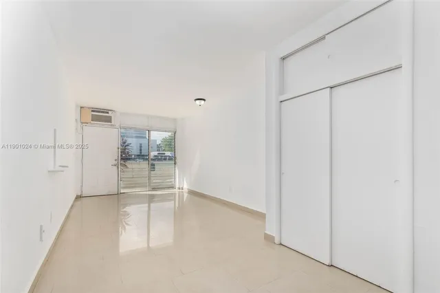 a hallway with white cabinets and white appliances