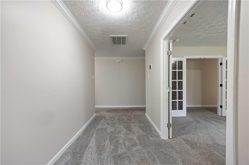 25 Gas Line Road Phenix City, AL 36870 - Photo 17 of 52 Hall with a textured ceiling, carpet floors, and crown molding