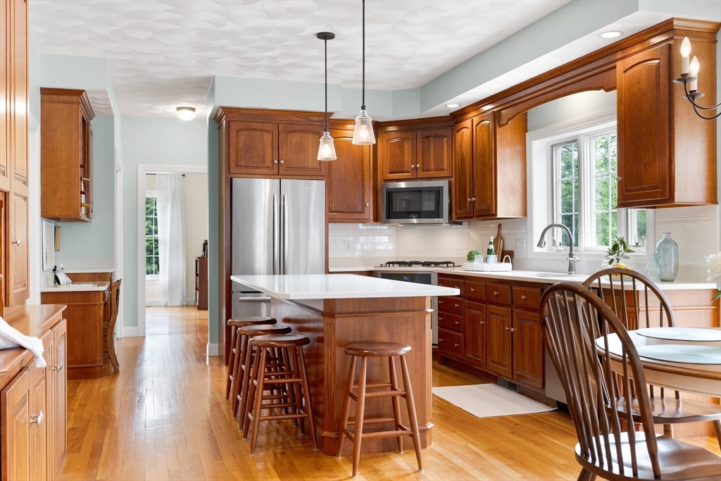 4 Coderre Way Andover, MA 01810 - Photo 14 of 35 a kitchen with stainless steel appliances granite countertop a refrigerator a sink a stove and a dining table with wooden floor