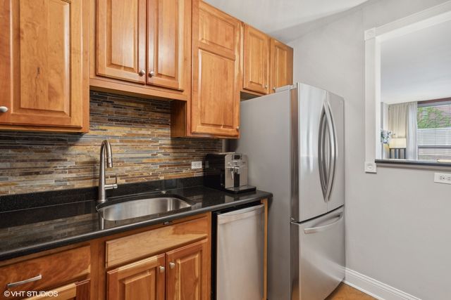 a kitchen with granite countertop a refrigerator and a sink