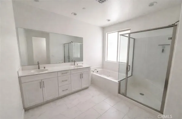 a bathroom with a tub sink shower and mirror