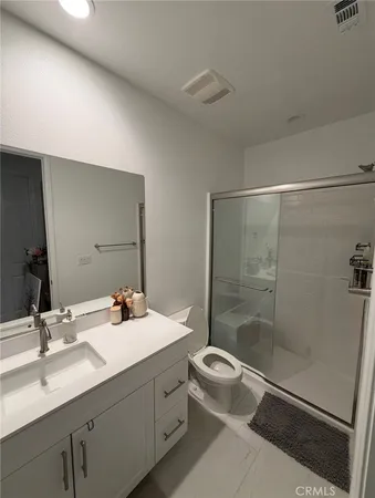 a bathroom with a double vanity sink toilet and shower