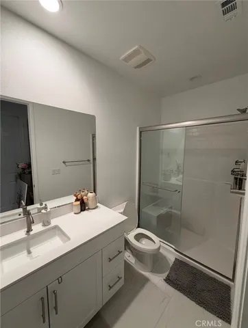a bathroom with a double vanity sink toilet and shower