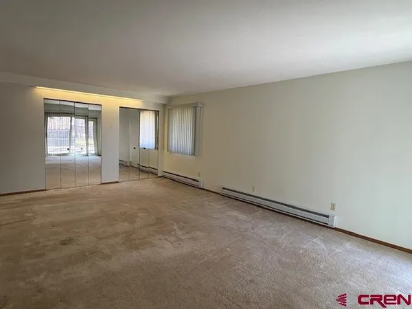 an empty room with windows and closet