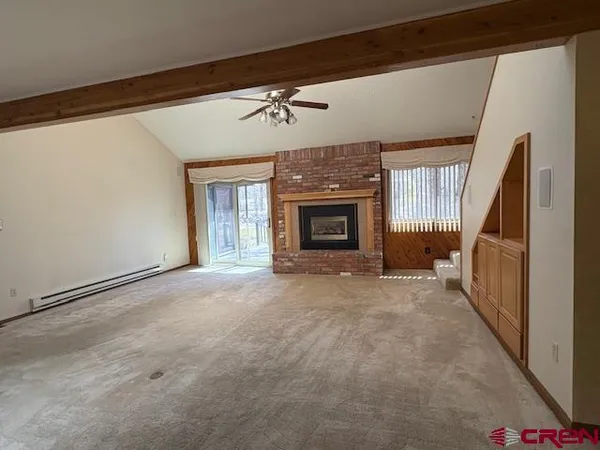 a view of empty room with fireplace and chandelier