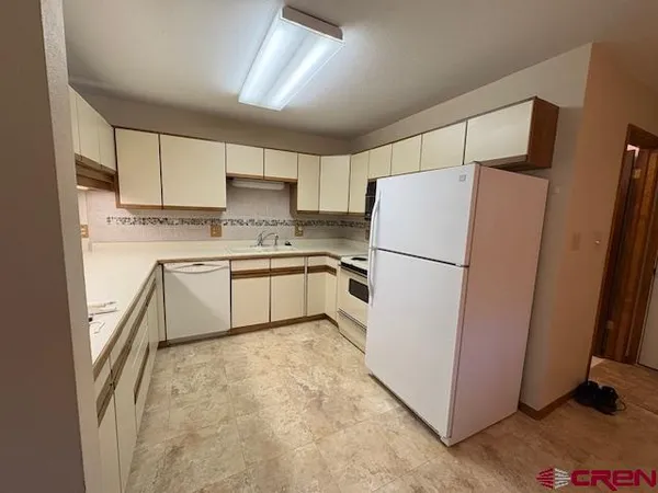 a kitchen with a refrigerator and a stove top oven