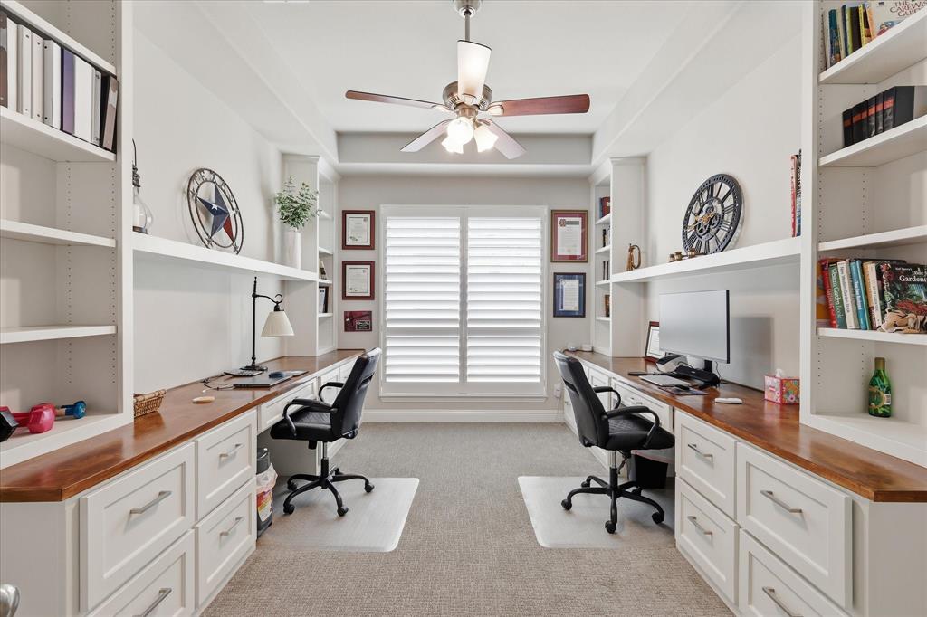 9708 Surveyor Road Oak Point, TX 75068 - Photo 14 of 34 Dedicated office space featuring dual built-in desks with wood-finish countertops, extensive white cabinetry, integrated shelving, and a ceiling fan
