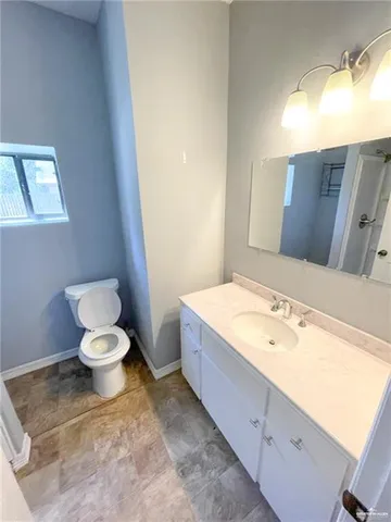 a bathroom with a granite countertop toilet and a sink