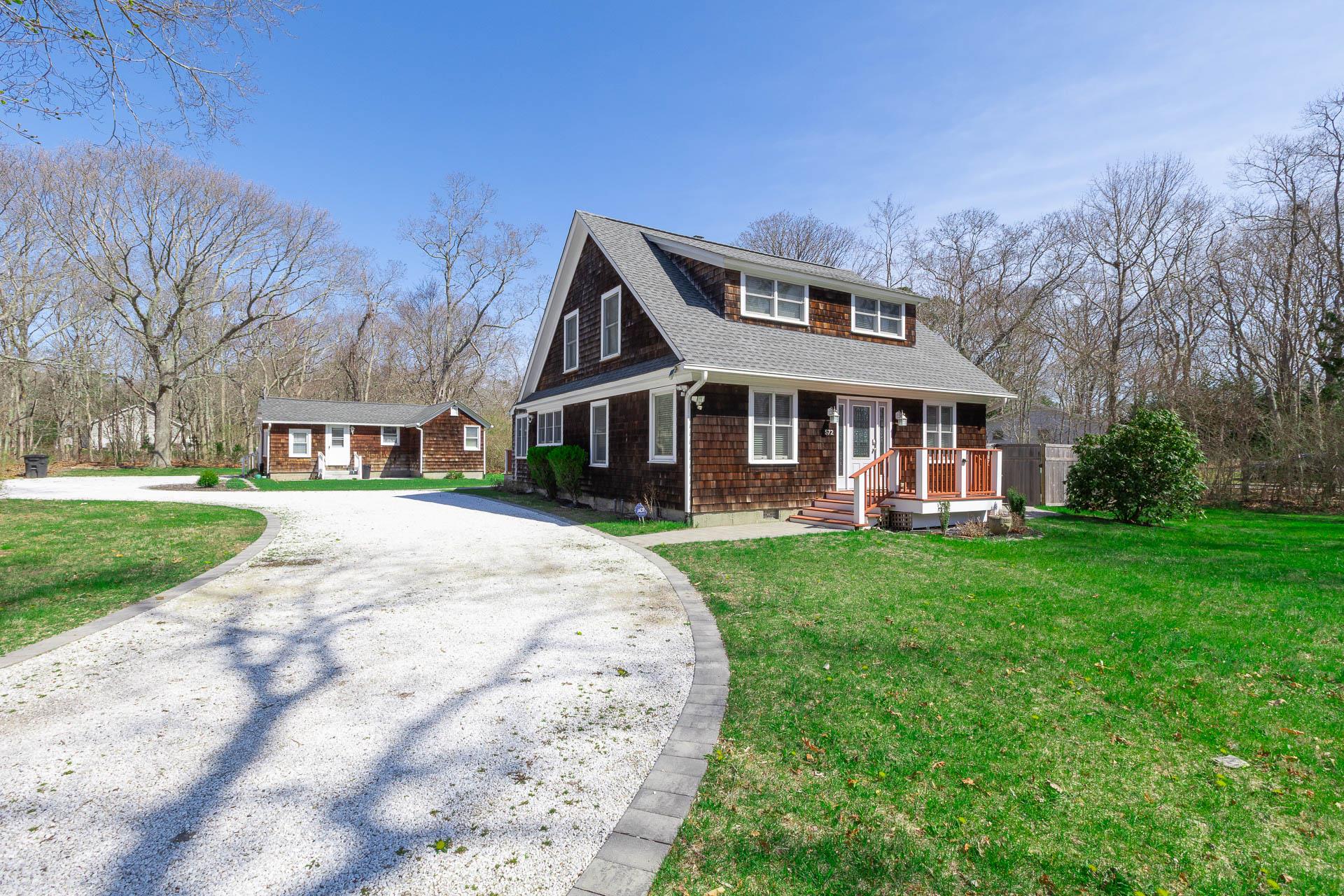 a front view of a house with yard and green space