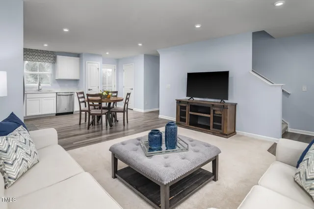a living room with furniture and kitchen view