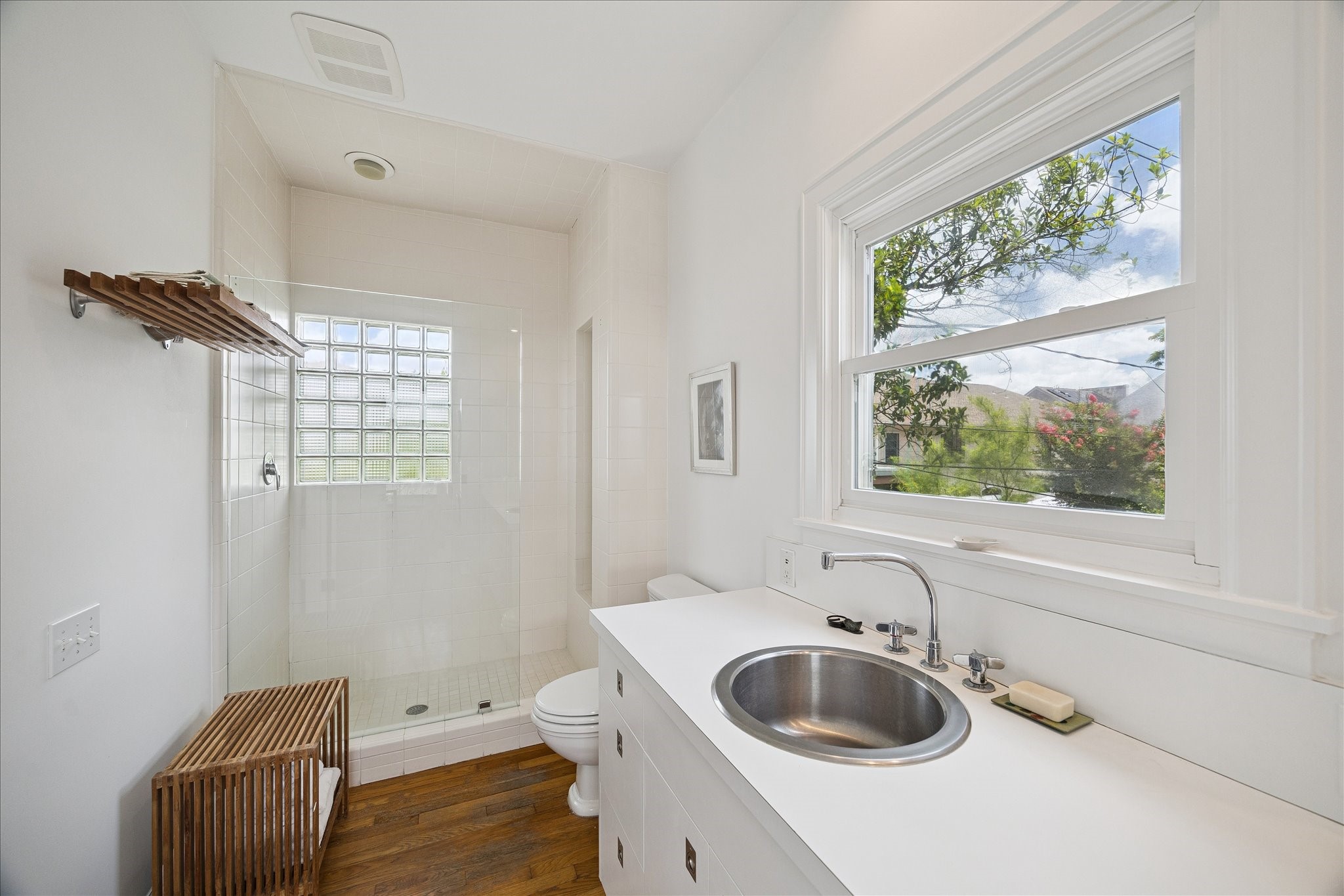 1418 Kipling Street Houston, TX 77006 - Photo 21 of 42 Original bathroom in all white as was designed by the architect. White shower tile with glass enclosure, white laminate counter top, and white cabinetry.
