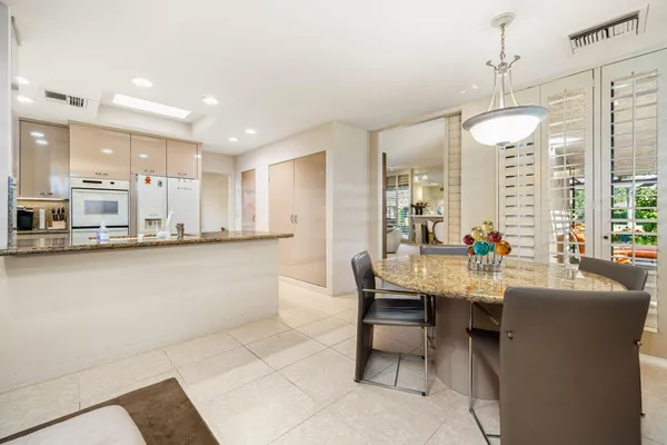 a kitchen with white cabinets stainless steel appliances and a window