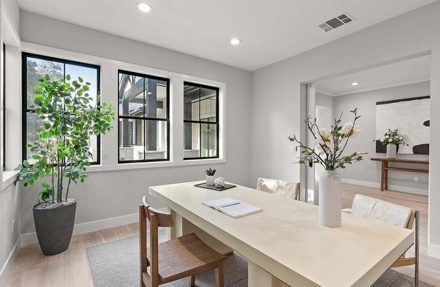 a dining room with furniture potted plants and wooden floor