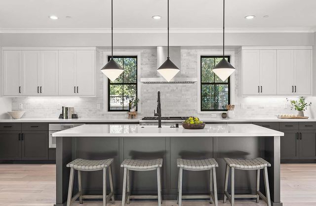 a kitchen with stainless steel appliances granite countertop a sink a stove and a refrigerator