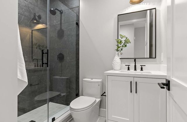 a bathroom with a sink a toilet and shower