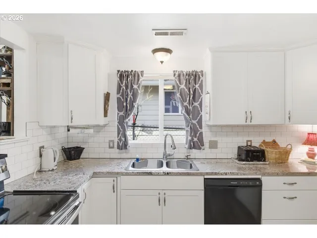 a kitchen with stainless steel appliances granite countertop a sink stove and cabinets