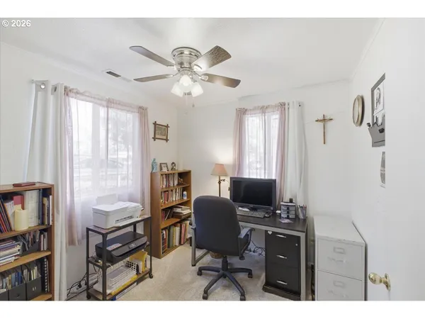 a view of a workspace with furniture and a window