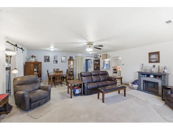a living room with furniture kitchen view and a window