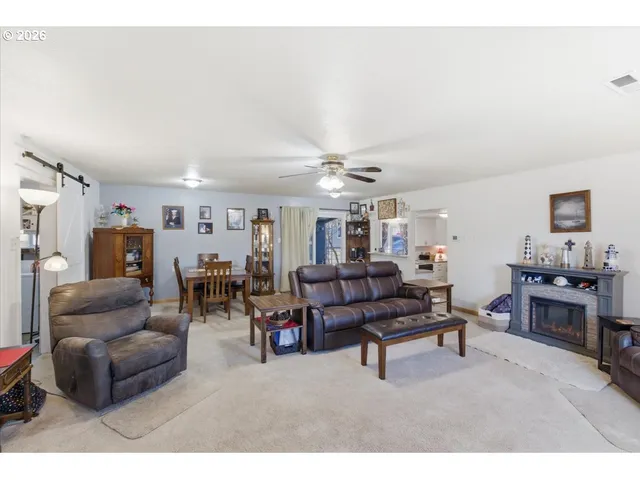 a living room with furniture kitchen view and a window