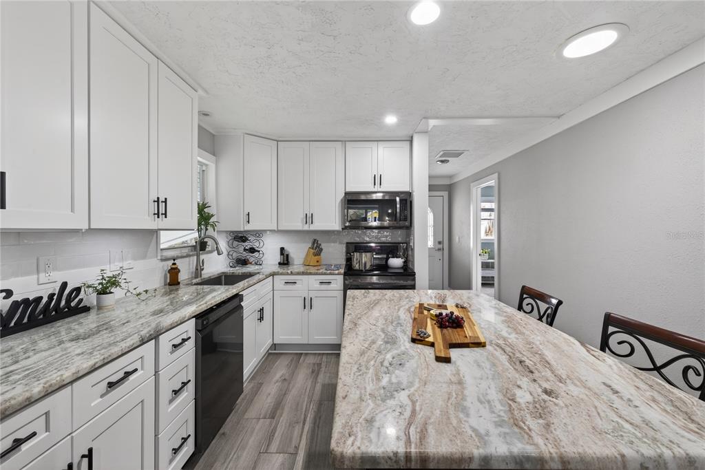 5851 Rio Drive New Port Richey, FL 34652 - Photo 15 of 50 a kitchen with granite countertop a sink stove and refrigerator