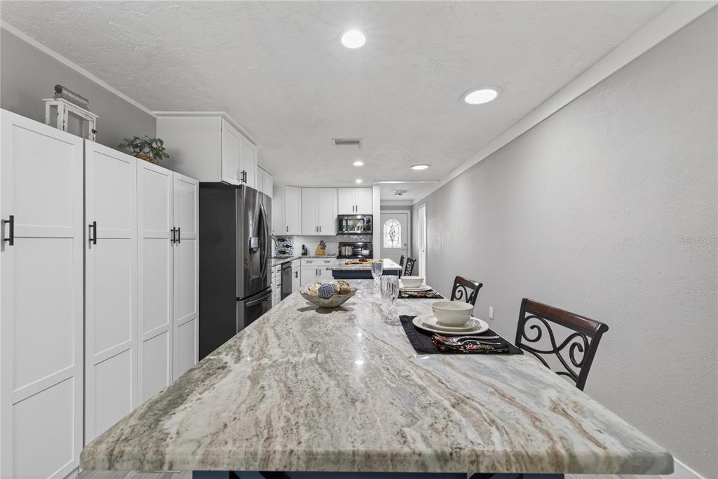 5851 Rio Drive New Port Richey, FL 34652 - Photo 17 of 50 a kitchen with stainless steel appliances kitchen island granite countertop a refrigerator and a sink