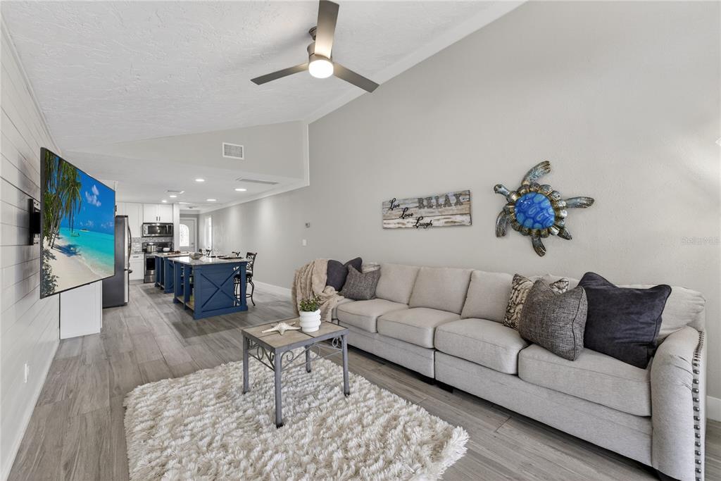 5851 Rio Drive New Port Richey, FL 34652 - Photo 9 of 50 a living room with furniture kitchen view and a flat screen tv