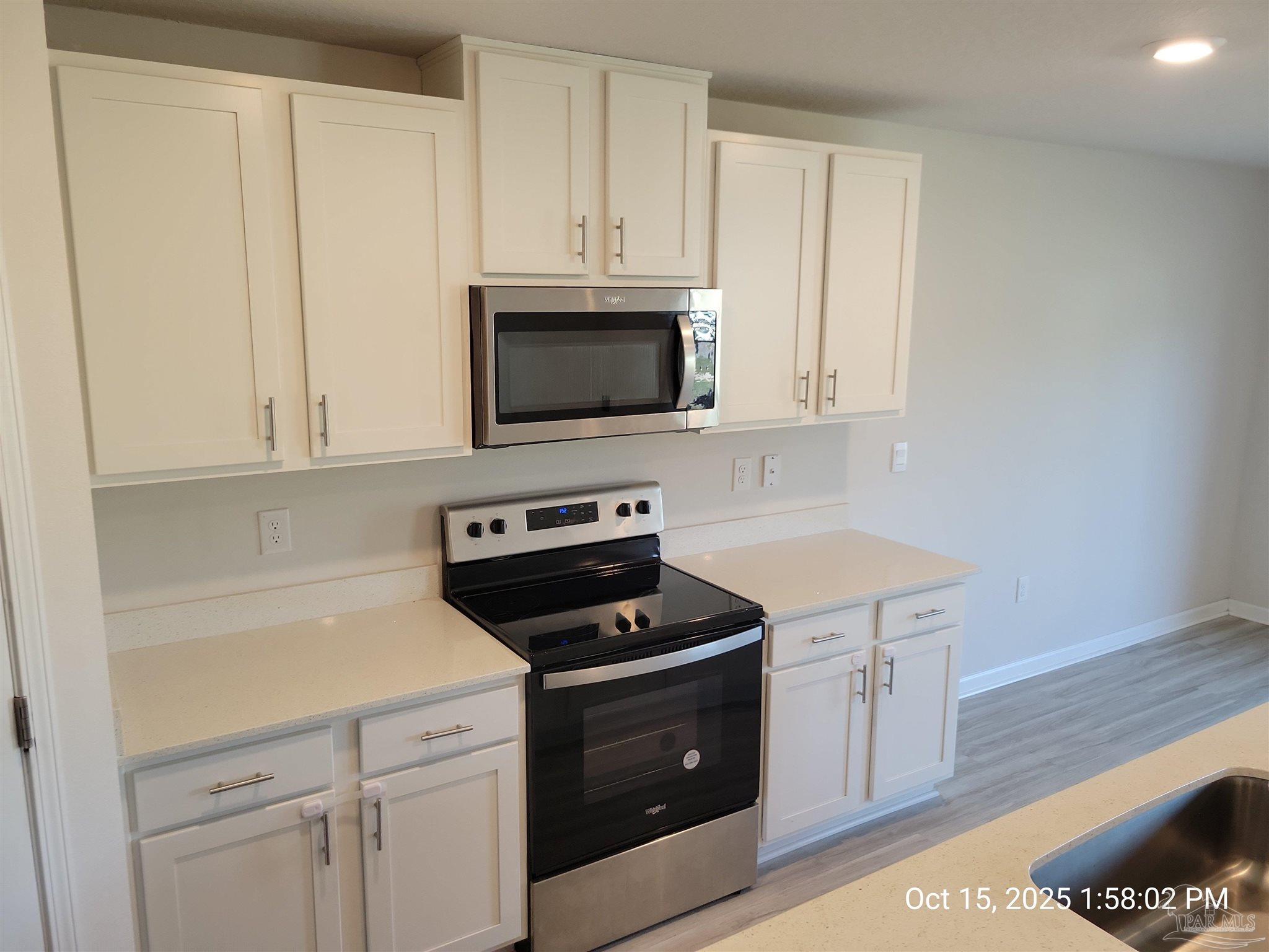 441 Scarborough Street Crestview, FL 32539 - Photo 7 of 13 a kitchen with cabinets appliances and a wooden floor