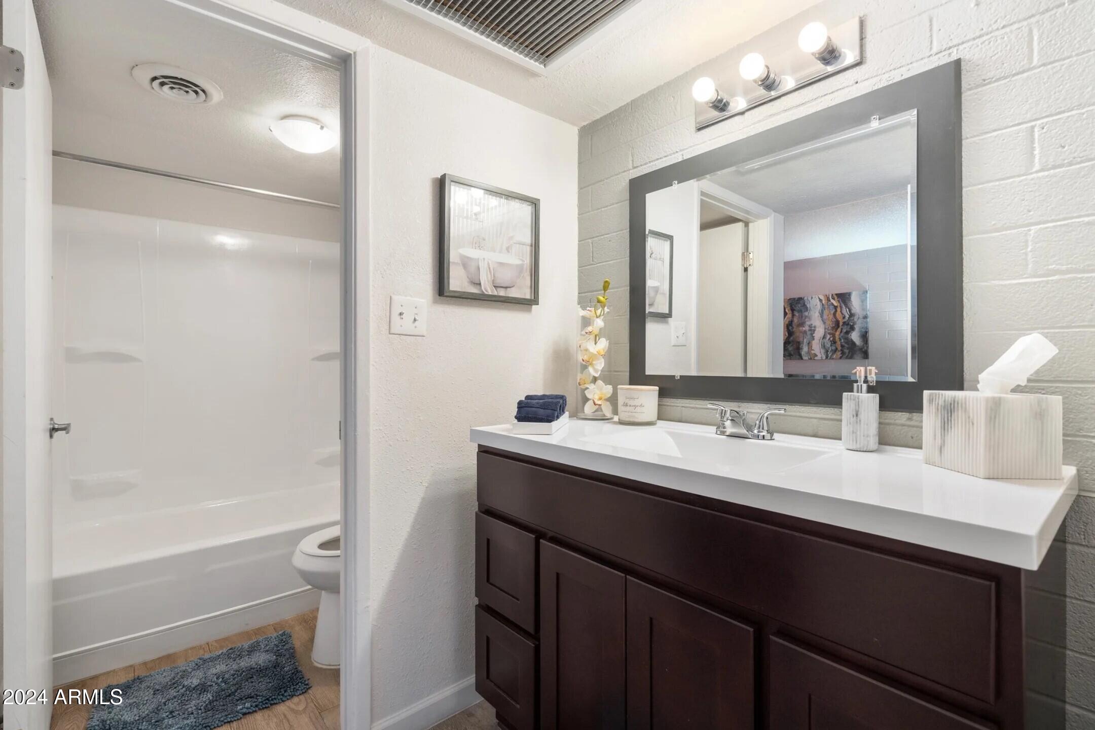 1601 West Camelback Road, Unit A10AW Phoenix, AZ 85015 - Photo 11 of 23 a bathroom with a sink vanity tub and a mirror