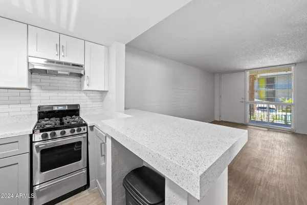 a kitchen with granite countertop a stove and a sink