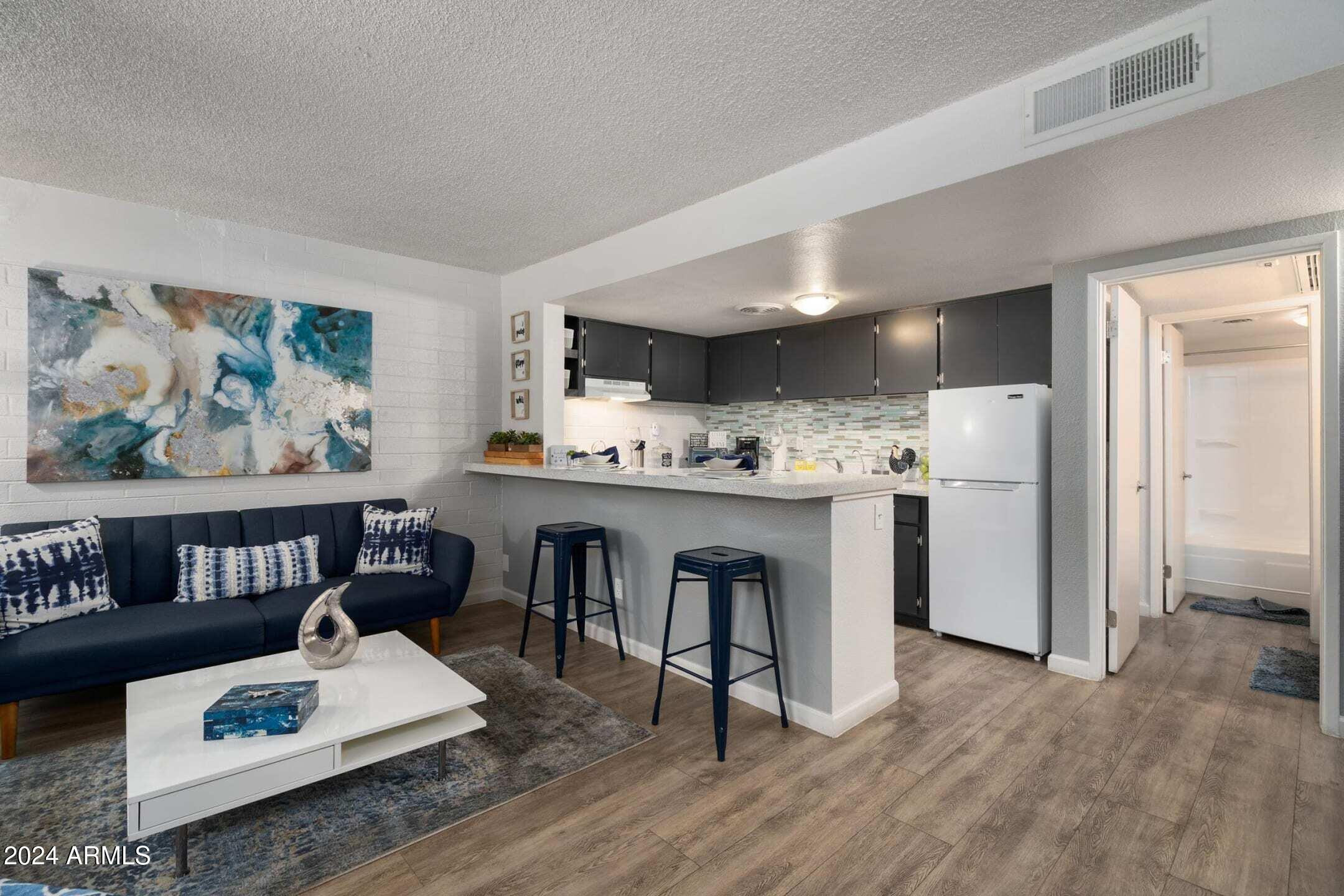 1601 West Camelback Road, Unit A10AW Phoenix, AZ 85015 - Photo 6 of 23 a living room with furniture and kitchen view