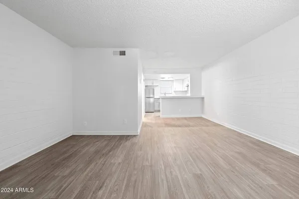 a view of a room with wooden floor and white walls