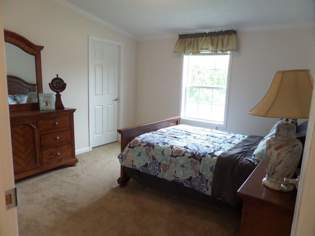 16 Hagop Road Salem, NH 03079 - Photo 5 of 8 a bed sitting in a bedroom next to a window and dresser