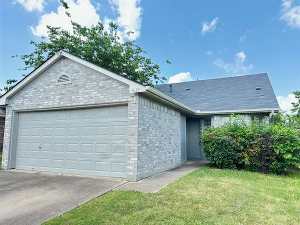 a view of a small house with a yard and garage
