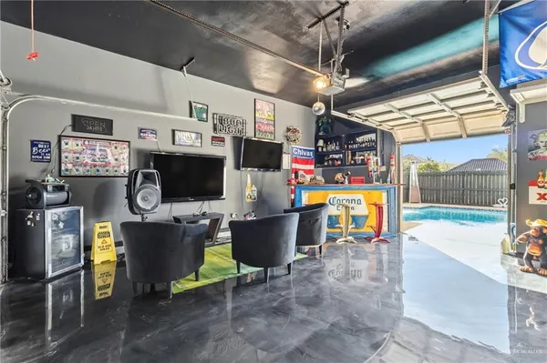a living room with patio furniture and a flat screen tv