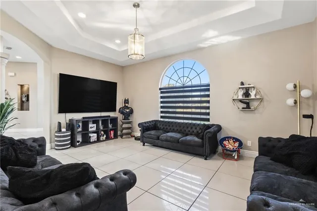 a living room with furniture a chandelier and a flat screen tv
