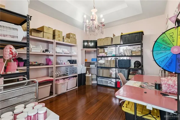 a kitchen with stainless steel appliances wooden floor and chandelier