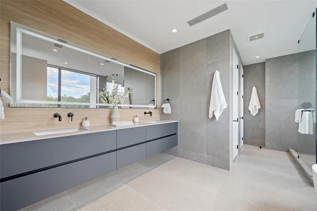 a bathroom with a double vanity sink mirror double and shower