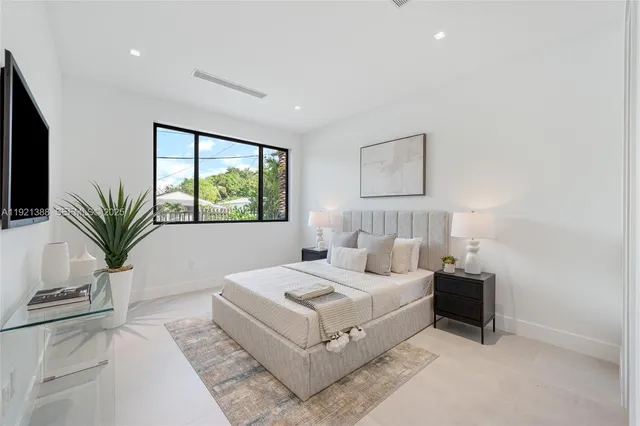 a bedroom with a large bed and a potted plant