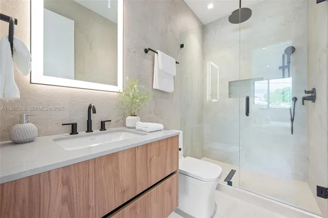 a bathroom with a granite countertop sink toilet and shower
