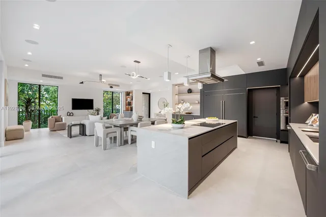 a large white kitchen with a large window and furniture