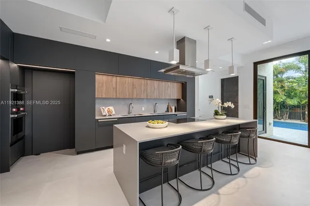 a kitchen with stainless steel appliances a table chairs refrigerator and wooden floor