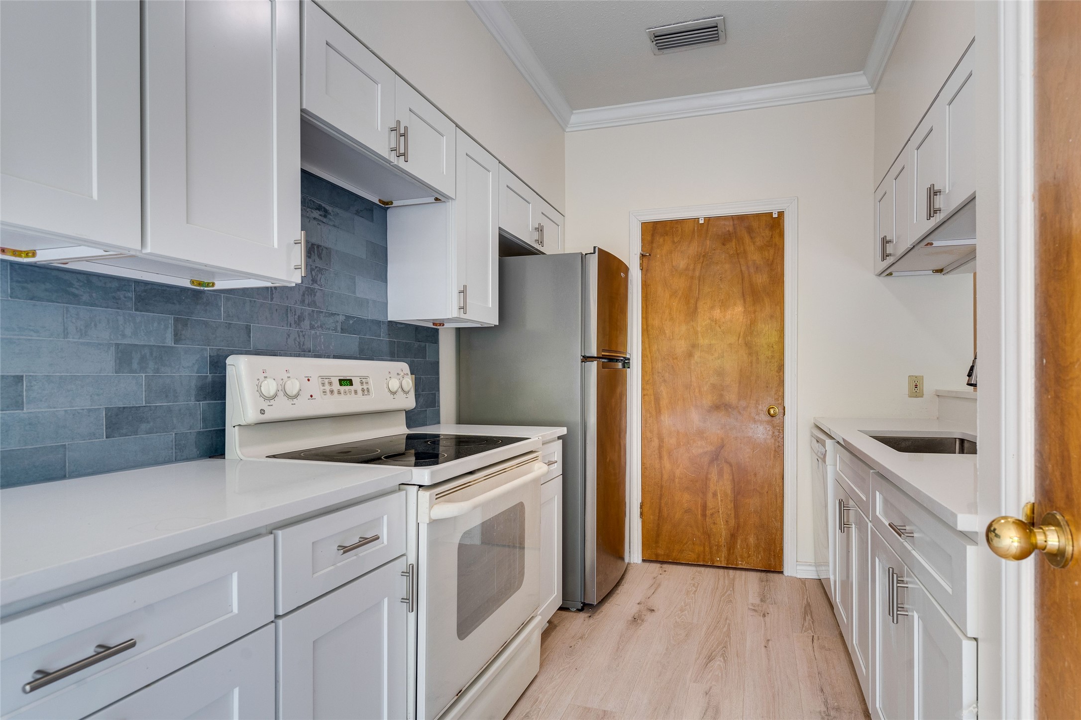 1406 Windsor Road, Unit 201 Austin, TX 78703 - Photo 12 of 32 a kitchen with a refrigerator sink and cabinets