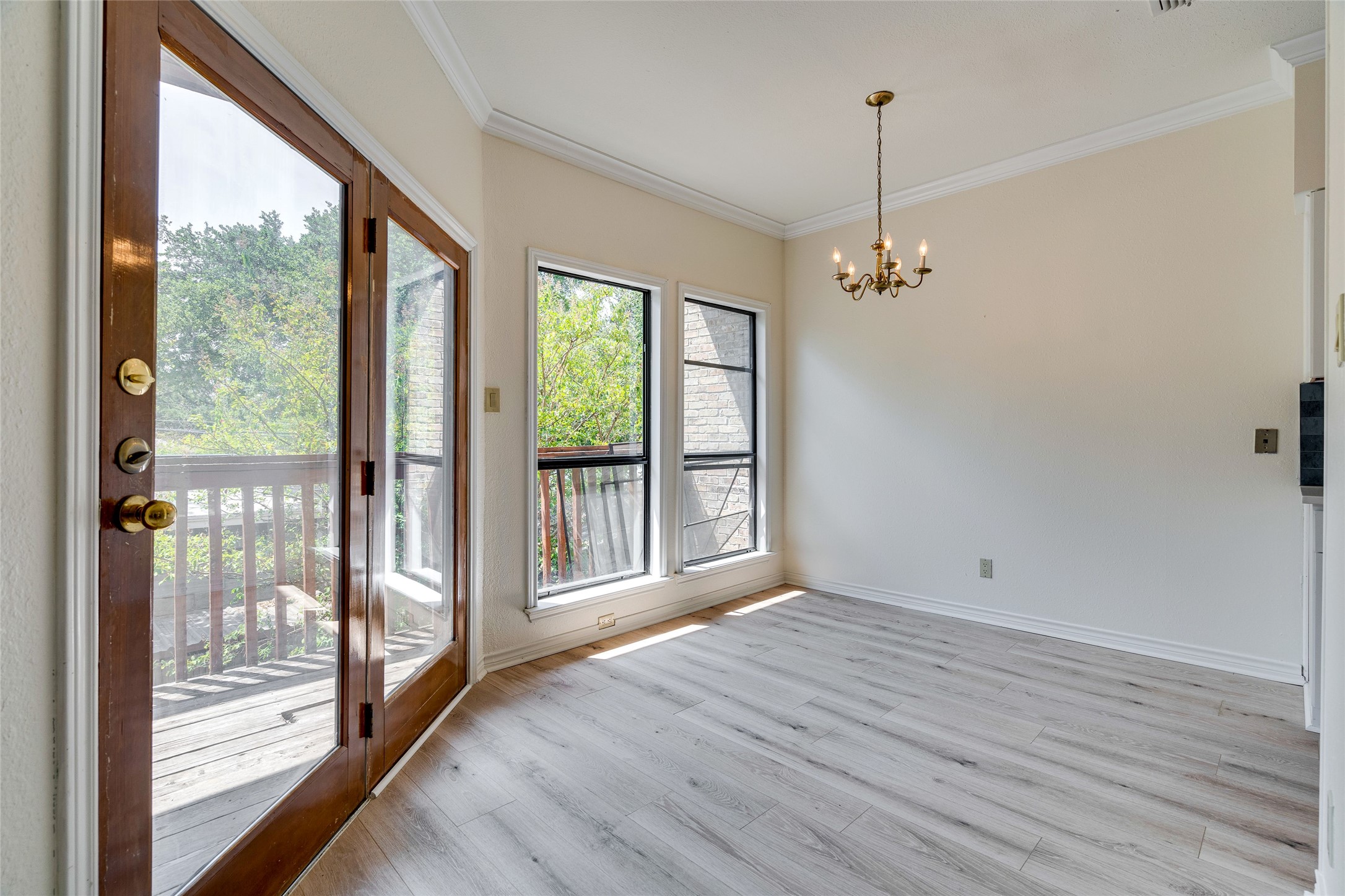 1406 Windsor Road, Unit 201 Austin, TX 78703 - Photo 6 of 32 a view of an empty room with wooden floor and a window