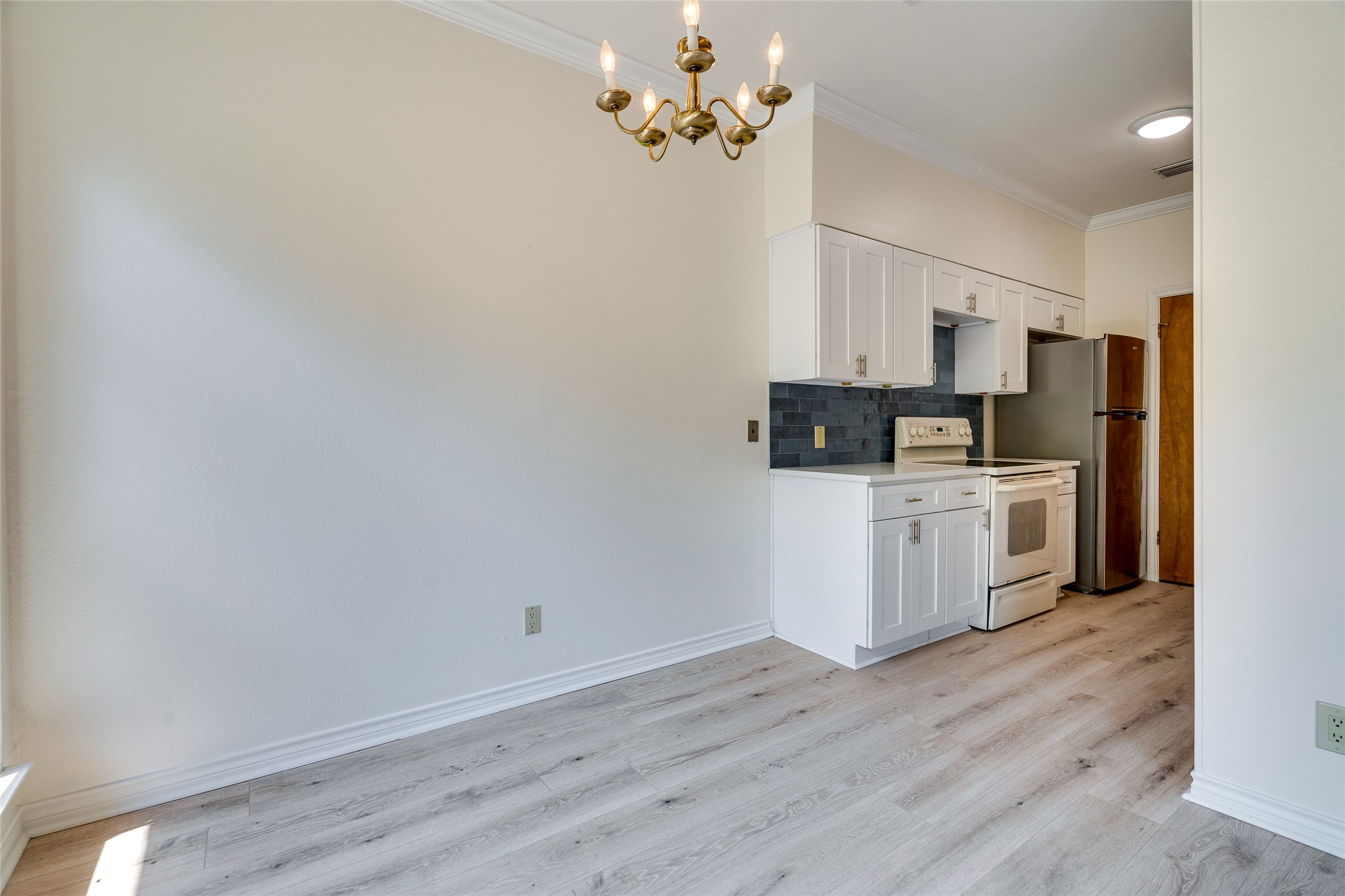 1406 Windsor Road, Unit 201 Austin, TX 78703 - Photo 8 of 32 a kitchen with stainless steel appliances a white stove top oven a refrigerator a sink and dishwasher with wooden floor