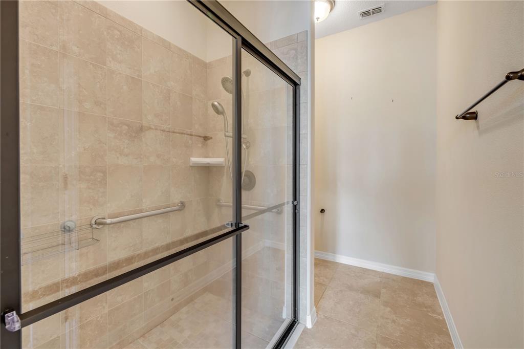 3329 Tuscano Avenue New Smyrna Beach, FL 32168 - Photo 12 of 36 a bathroom with a glass shower door